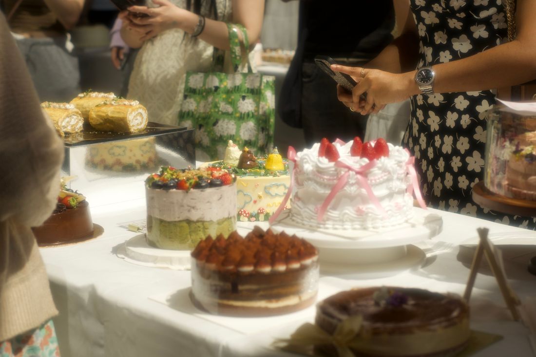 Guests photographing a table of cakes