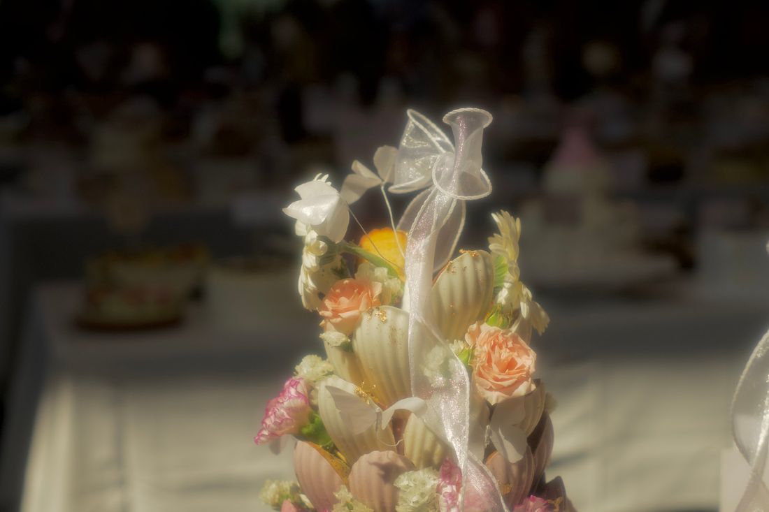 A flower and madeleine dessert tower tied with ribbon