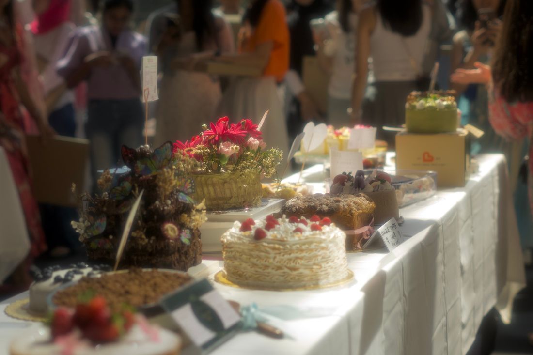A long table of decorated cakes at a dinner-style event