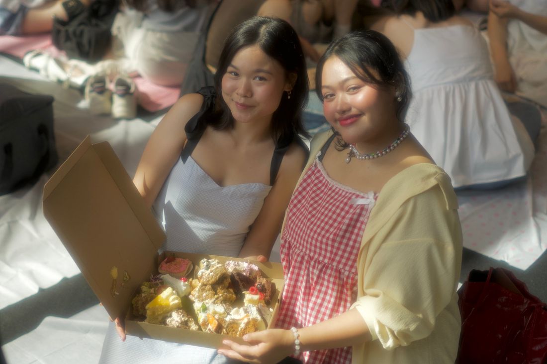 Two friends with a box of cake slices at Cakewalk