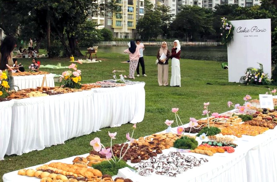 Long tables of cookies beside the Cookie Picnic backdrop