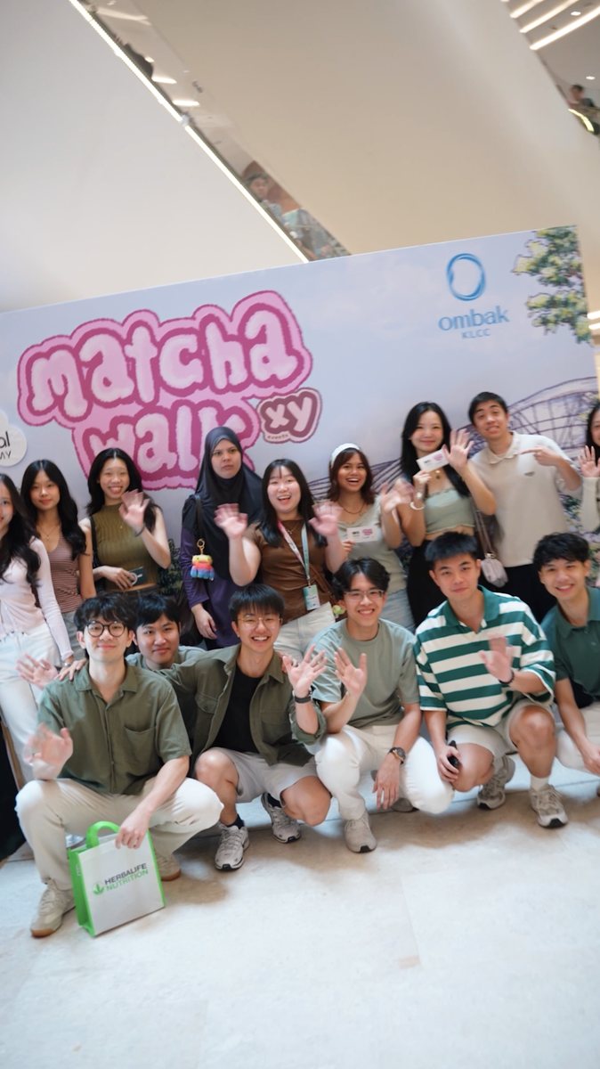 A big group waving in front of the MATCHAWALK backdrop