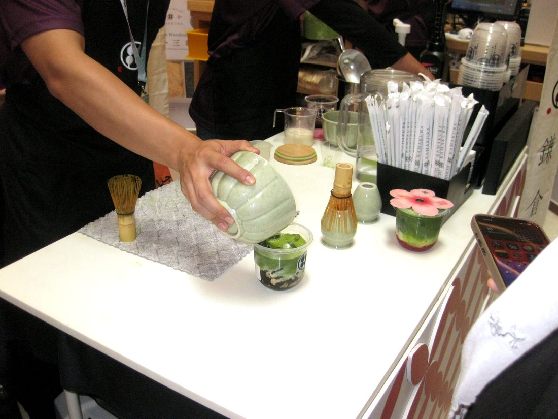 Matcha poured from a ceramic bowl over an iced drink