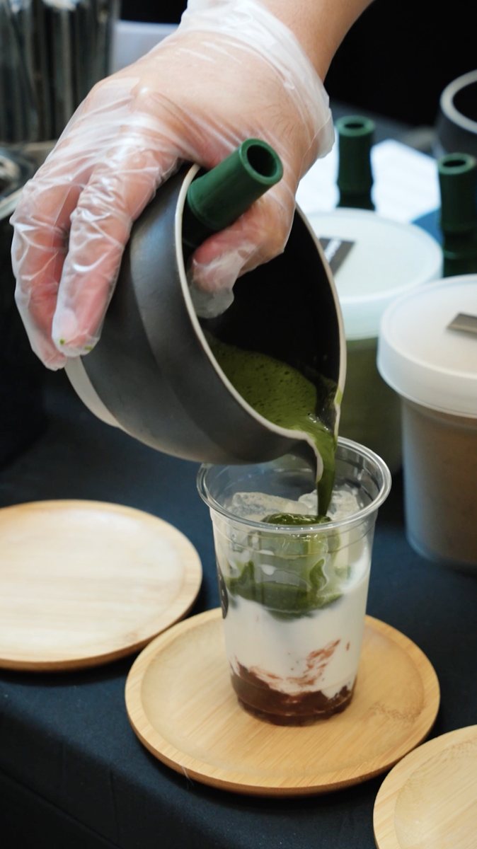Matcha being poured over milk and red bean